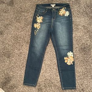 Blue jeans with a flower decal on the legs and pockets area